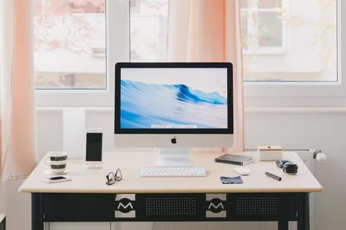 Apple iMac on a desk in a bright room